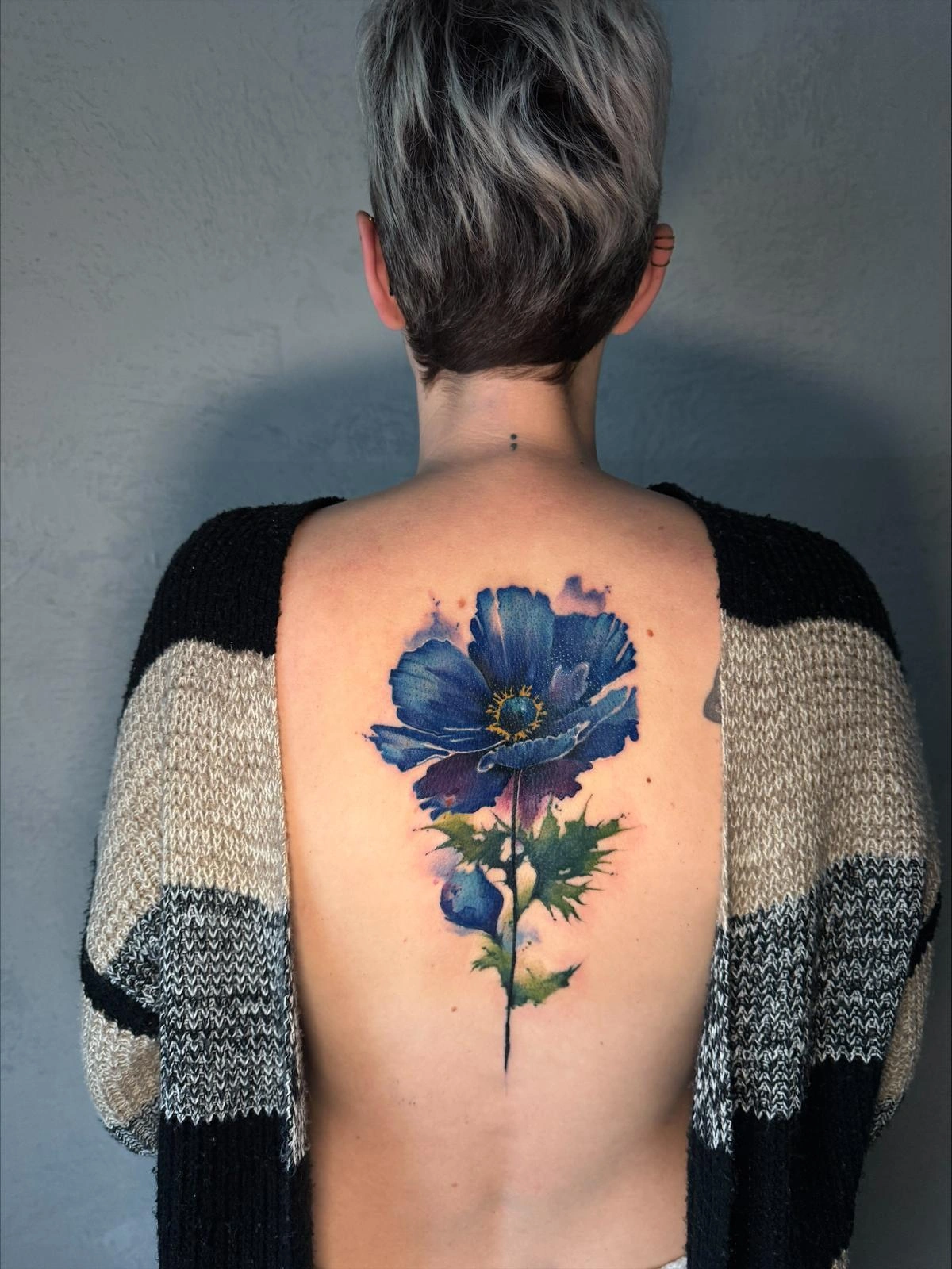 Blaues Blüten-Tattoo auf dem oberen Rücken