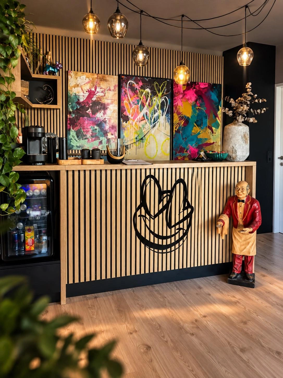 Anitas Studio mit Holztheke, ihrem Logo, Gemälden und warmen Pendelleuchten